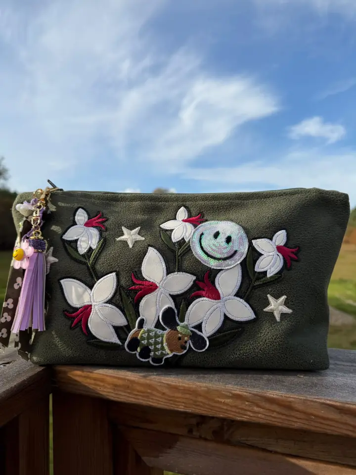 Pochette noire MissPom' avec fleurs blanches et visages souriants